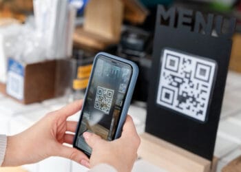 Ilustrasi smartphone dengan kode QR di layar, menggambarkan potensi bahaya di balik tampilan kode yang tampak biasa saja. (Sumber: esb.id)