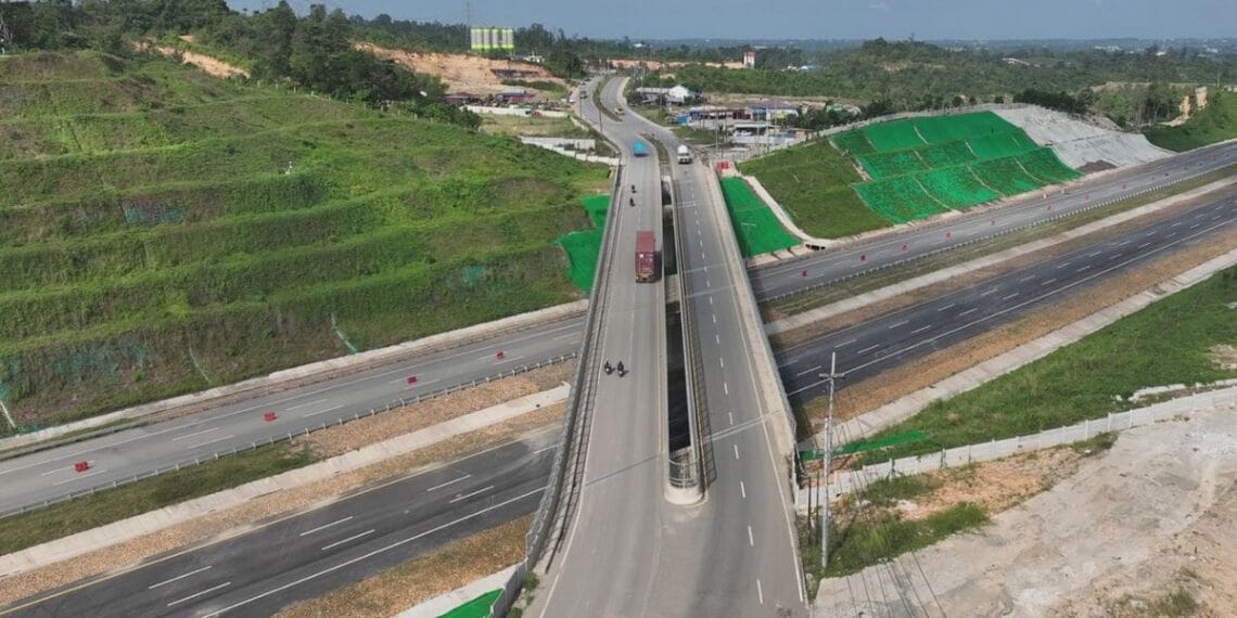 Jalan tol baru IKN Seksi 3A tampak berdiri kokoh, melintasi areal hijau dan menunjukkan salah satu kemajuan besar infrastruktur nasional—mewakili konektivitas cepat antara Balikpapan dan IKN Nusantara. (Sumber: Hutama Karya)