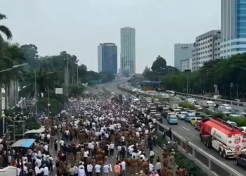 mengatur lalu lintas di sekitar Tol Kuningan 2 untuk mengurai kepadatan akibat demo. (Sumber: Antara)