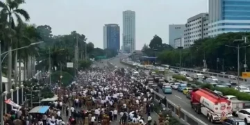 mengatur lalu lintas di sekitar Tol Kuningan 2 untuk mengurai kepadatan akibat demo. (Sumber: Antara)