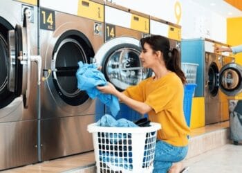 Seorang pekerja laundry sedang mengemasi pakaian bersih di titik layanan di Jakarta, menggambarkan aktivitas harian industri jasa laundry. (Sumber: Idebiz.id)