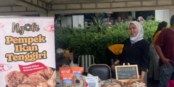 Enih, seorang ibu rumah tangga, berhasil membesarkan bisnis camilannya lewat program Rumah BUMN binaan BRI. Dari dapur rumah hingga produk kini hadir di etalase bandara dan supermarket.  Foto: dok: BRI