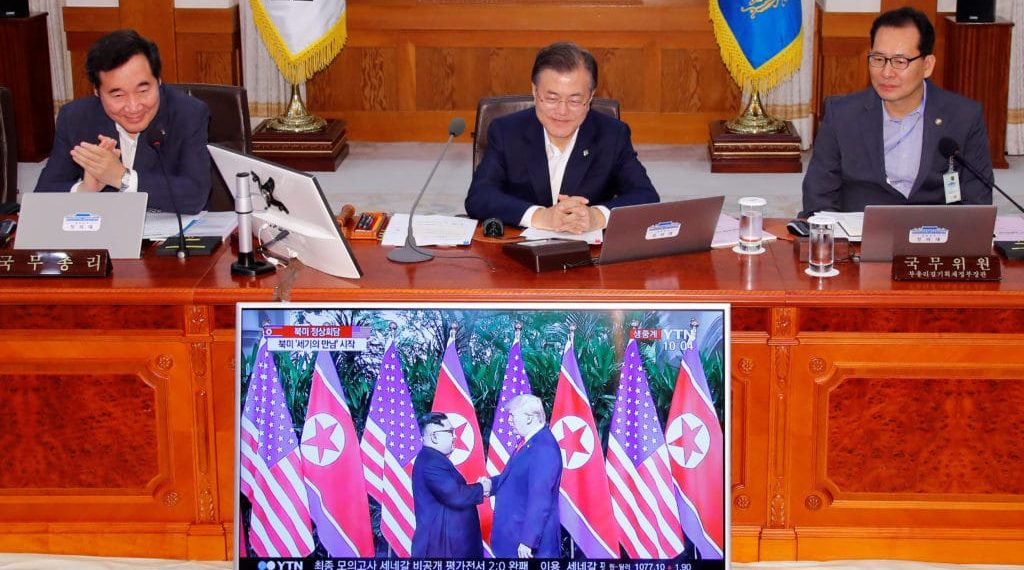 Presiden Korea Selatan Lee Jae Myung (tengah) saat pertemuan diplomatik, latar bendera Korea Selatan dan Amerika Serikat. (Sumber: PBS/Reuters)