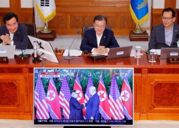 Presiden Korea Selatan Lee Jae Myung (tengah) saat pertemuan diplomatik, latar bendera Korea Selatan dan Amerika Serikat. (Sumber: PBS/Reuters)