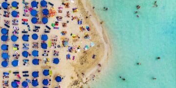 Suasana pantai yang sangat ramai—tumpah ruah pengunjung di sepanjang pasir dan tepian laut, menggambarkan betapa padatnya beberapa pantai wisata favorit dunia. Sumber: Dreamstime