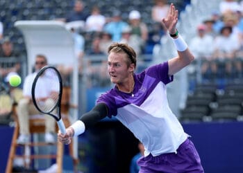 Sebastian Korda sedang melakukan pukulan penuh tenaga di Winston-Salem Open, menggambarkan semangat juangnya dalam meraih satu tempat di perempatfinal. Sumber: Getty Images via TennisThreads