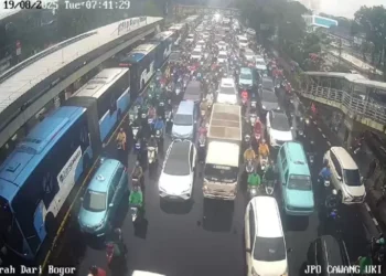 Pemandangan macet di Cawang pagi ini—bus TransJakarta dan kendaraan lain tampak mengantre di tengah hujan deras. (Sumber: SindoNews)