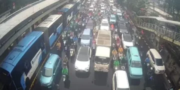 Pemandangan macet di Cawang pagi ini—bus TransJakarta dan kendaraan lain tampak mengantre di tengah hujan deras. (Sumber: SindoNews)