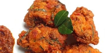 Ayam goreng terasi dengan taburan daun jeruk yang harum, siap disajikan di meja makan. (Sumber: viva.co.id)