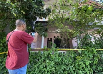 Rumah berlantai dua dengan cat merah muda yang memudar—lokasi penemuan jenazah satu keluarga yang terkubur di dalam rumah. (Sumber: KOMPAS.com/HANDHIKA RAHMAN)