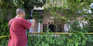 Rumah berlantai dua dengan cat merah muda yang memudar—lokasi penemuan jenazah satu keluarga yang terkubur di dalam rumah. (Sumber: KOMPAS.com/HANDHIKA RAHMAN)