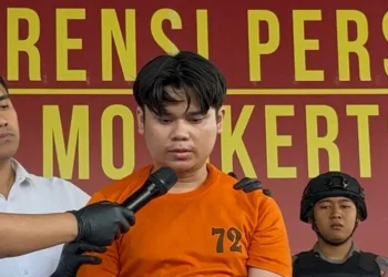 Alvi Maulana, tersangka kasus mutilasi pacar, saat diperlihatkan ke publik dengan pakaian tahanan berwarna oranye. (Sumber: Enggran Eko Budianto/detikJatim)