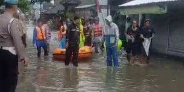 Evakuasi balita dan lansia di Denpasar oleh tim SAR menggunakan perahu karet—tampak warga terdampak banjir sedang dipindahkan ke tempat aman. (Sumber: balipost.com)