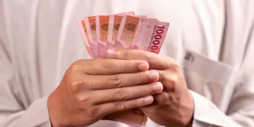 Ilustrasi calon penerima BSU sedang melakukan pengecekan status melalui perangkat elektronik. (Sumber: canva via metropolitan.id)