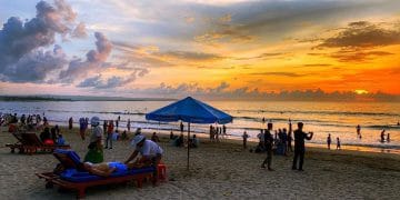 Pantai Kuta saat senja—langit jingga berpadu sempurna dengan ombak tenang dan pasir putih yang memesona. (Sumber: Tripcetera.com)