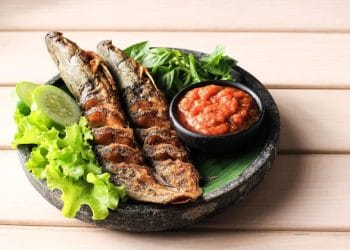 Seporsi lele goreng lengkap dengan sambal dan lalapan—menu sederhana yang mencerminkan kelezatan dan manfaat harian. (Sumber: Freepik via detikFood)