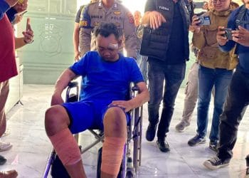 Salah satu dari dua pelaku kasus pembunuhan satu keluarga di Kabupaten Indramayu, dihadirkan di Mapolda Jawa Barat dengan kondisi memakai baju tahanan. Pelaku sempat ditembak di bagian kaki karena melakukan perlawanan saat penangkapan. (Sumber: detikNews / Wisma Putra)