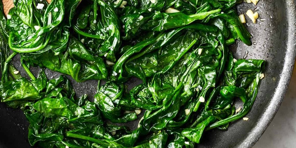 Olahan bayam segar ditumis cepat bersama bawang putih—menampilkan warna hijau cerah dan tekstur yang menggugah selera, mencerminkan cara memasak bayam yang tetap sehat dan lezat. (Sumber: Love and Lemons via X)