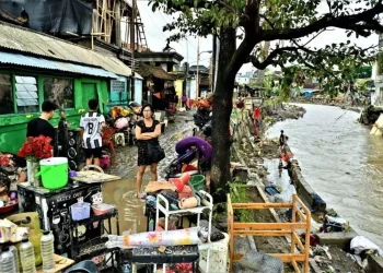 Warga sedang mengevakuasi barang dari rumah yang terendam banjir di Bali setelah hujan lebat. (Sumber: ANTARA Photo/Fikri via popbela.com)