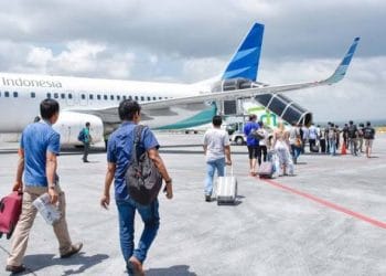 Ilustrasi wisatawan di bandara membawa koper liburan. (Foto: beritatrans.com)