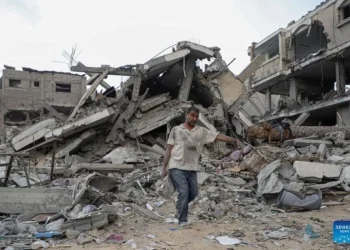 Pekerja kemanusiaan berjalan di antara reruntuhan pascaserangan udara di Gaza. (Sumber: ANTARA/Rizek Abdeljawad/Xinhua/tm)
