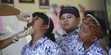 Indonesia resmi menutup KLB polio setelah dua tahun respons intensif. Upaya imunisasi massal dan penguatan surveilans menjadi kunci keberhasilan. (Foto: AP/Firdia Lisnawati)