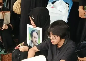 Karina Ranau menangis dalam mobil jenazah sambil mengucapkan pesan cinta terakhir untuk suaminya, Epy Kusnandar, yang meninggal pada usia 61 tahun. (Foto: Tribunnews.com/M Alivio Mubarak Junior)