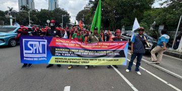 Aksi demo buruh di Jalan Medan Merdeka Selatan membuat lalu lintas menuju Patung Kuda macet panjang. Massa buruh menuntut kenaikan Upah Minimum Provinsi Jakarta. (Foto: Andreas Kristianto/Bloomberg Technoz)