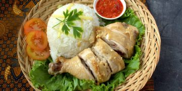Simak resep nasi ayam Hainan ala Singapura dengan nasi gurih berkaldu dan ayam rebus yang wangi jahe serta mudah dibuat di rumah.
